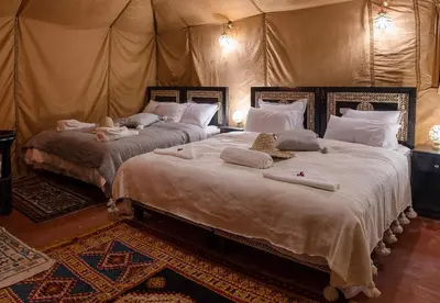 two large beds in a room with a tent at Sands Charm Luxury Camp in Merzouga