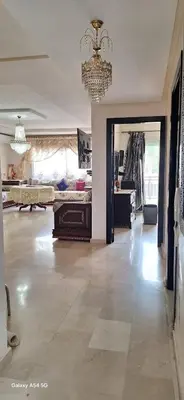 a large living room with a chandelier and a large room with at Fes Magic Apartment - With Swimming pool in Fès