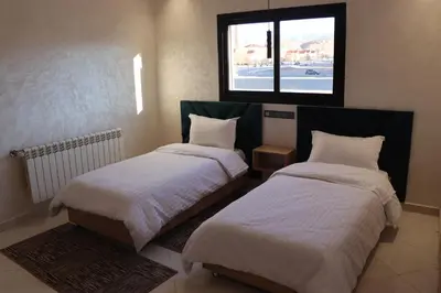 two beds in a room with a window at VANA hôtel in Midelt
