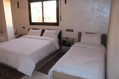 a bedroom with two beds and a window at VANA hôtel in Midelt