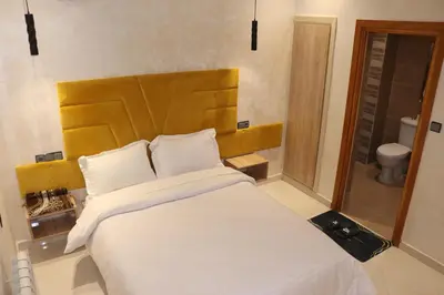a bedroom with a large bed with a wooden headboard at VANA hôtel in Midelt