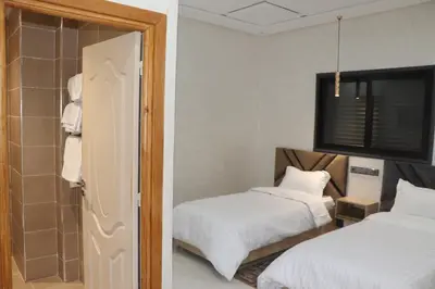 a room with two beds and a bathroom with a mirror at VANA hôtel in Midelt