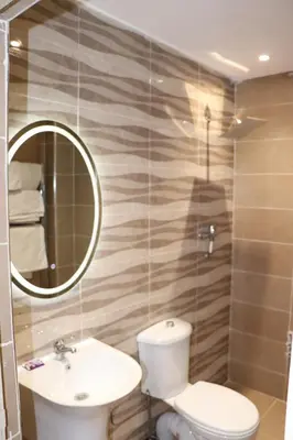 a bathroom with a toilet and a sink and a mirror at VANA hôtel in Midelt