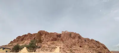 a rocky mountain with a building on top of it at Home Amazigh Serenity in Tinerhir