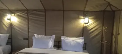 a bedroom with a canopy bed with white pillows at Golden Gate Luxury in Merzouga