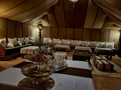 a living room with a couch and tables in a tent at Golden Gate Luxury in Merzouga