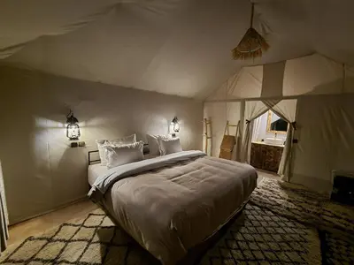 a bedroom with a large bed in a tent at Golden Gate Luxury in Merzouga