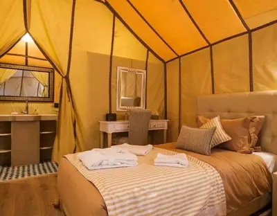 a bedroom with a bed in a tent at Merzouga Dunes Camp in Merzouga