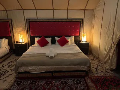a bedroom with a large bed in a tent at Merzouga Dunes Camp in Merzouga