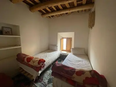 a room with two beds and a couch in it at Gite d'étape Chez Brahim in Kalaat MGouna