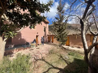 a person walking in front of a house at Gite d'étape Chez Brahim in Kalaat MGouna
