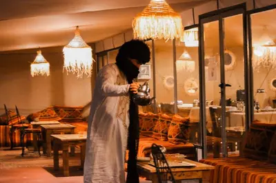 a woman standing in a store looking at her phone at Paradise Luxury Camp in Merzouga