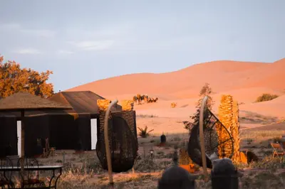 a group of people standing in front of a building in the desert at Paradise Luxury Camp in Merzouga