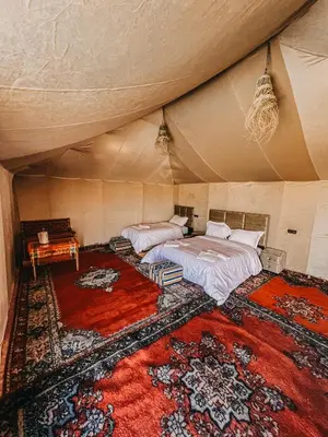 a bedroom with two beds in a tent at Paradise Luxury Camp in Merzouga