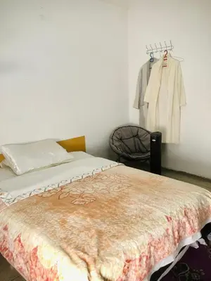 a bedroom with a bed and a clothes rack at Cyrnos in Fès