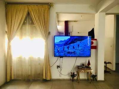 a living room with a flat screen tv on a wall at Cyrnos in Fès