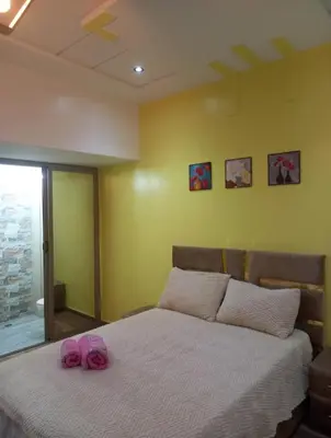 a bedroom with a bed with two pink slippers on it at ain chekef in Douar Oulad Mhammed