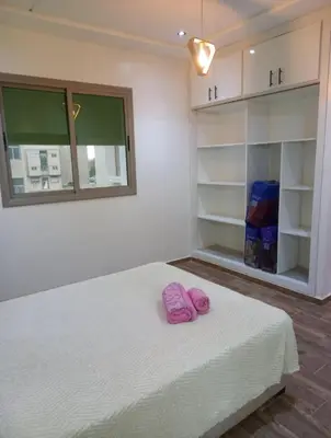 a bedroom with a bed with pink slippers on it at ain chekef in Douar Oulad Mhammed