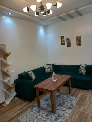 a living room with a green couch and a table at ain chekef in Douar Oulad Mhammed