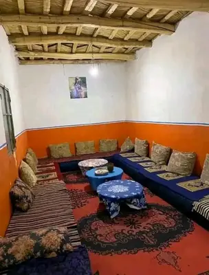 a living room with couches and tables in a room at Gîte du lac chez bennouri in Telouet