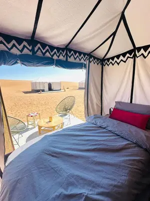a bed in a tent on the beach at Nomademoi Luxury Camp in El Gouera