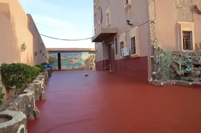 an alley with red water in the middle of a building at Kasbah Tasseurte in Kalaat MGouna