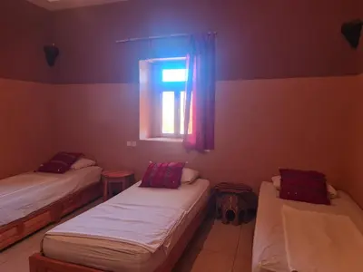 a room with two beds and a window at Kasbah Tasseurte in Kalaat MGouna