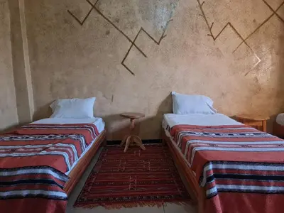 two beds sitting next to each other in a room at Kasbah Tasseurte in Kalaat MGouna