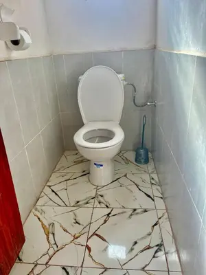 a bathroom with a toilet on a marble floor at Gite Megdaz Ouhadouch in Megdaz