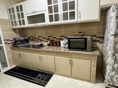 a kitchen with a counter with a microwave and a sink at Appartement 2 Chambres à Hamria Meknès in Meknès
