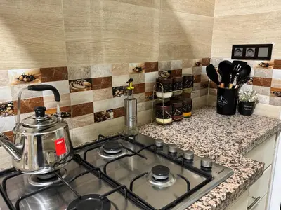 a kitchen stove top with a tea kettle on it at Appartement 2 Chambres à Hamria Meknès in Meknès
