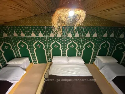 a room with two beds and a chandelier at Merzouga Camp & 4x4 Transfeer Include in Merzouga