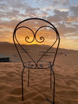 a chair sitting in the sand on a beach at Merzouga Camp & 4x4 Transfeer Include in Merzouga