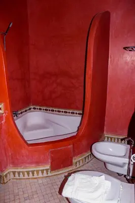 a red bathroom with a tub and a toilet at Hotel Ksar Kaissar in Kalaat MGouna