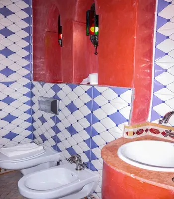 a bathroom with a white toilet and a sink at Hotel Ksar Kaissar in Kalaat MGouna