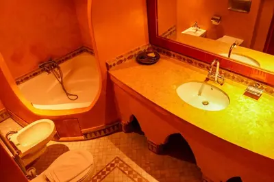 a bathroom with a sink and a tub and a toilet at Hotel Ksar Kaissar in Kalaat MGouna