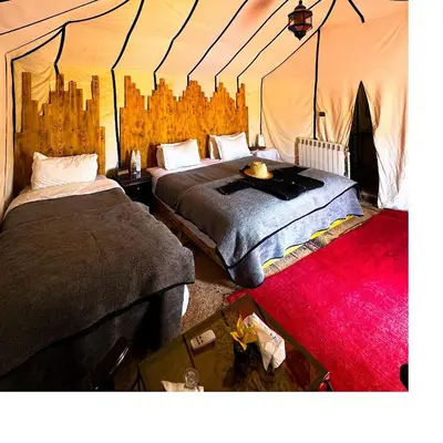 a bedroom with two beds in a tent at Dune Glamp Camp in Merzouga