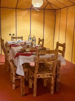 a table in a tent with a table and chairs at Dune Glamp Camp in Merzouga