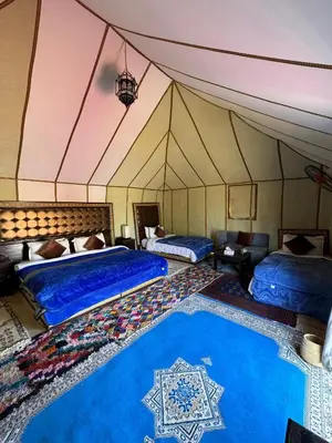 a bedroom with two beds in a tent at Dune Glamp Camp in Merzouga
