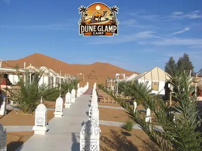 a row of gravestones with a dmg clark camp sign in the background at Dune Glamp Camp in Merzouga