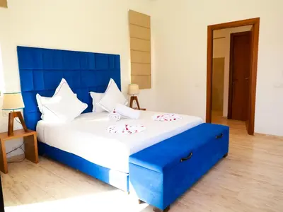 a blue and white bed in a room at Villa des iris Domaines NAJMA in Marrakech