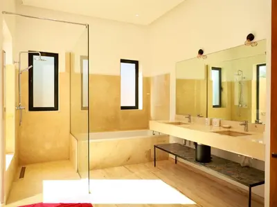 a bathroom with two sinks and a shower at Villa des iris Domaines NAJMA in Marrakech