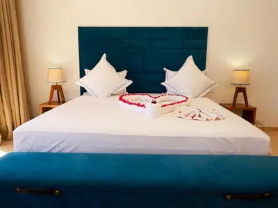 a bed with a blue headboard and white pillows on it at Villa des iris Domaines NAJMA in Marrakech