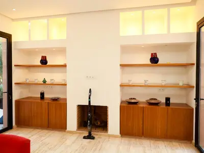 a living room with wooden cabinets and shelves at Villa des iris Domaines NAJMA in Marrakech