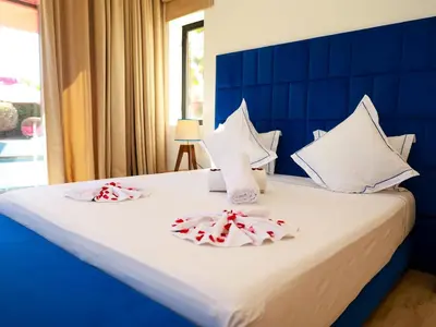 a bedroom with a blue and white bed with towels at Villa des iris Domaines NAJMA in Marrakech