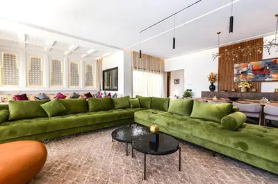 a living room with a green couch and a table at Villa Stella! Élégante & piscine sans vis à vis in Marrakech