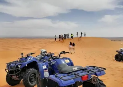 a blue atv parked in the sand on a beach at Sahara horizon Camp in Merzouga