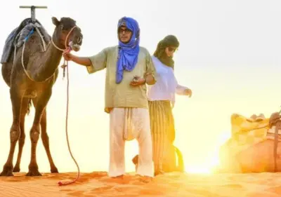 a man and a woman standing next to a horse at Sahara horizon Camp in Merzouga