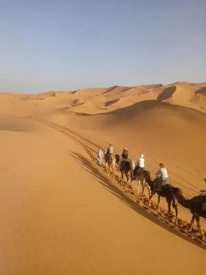 a group of people riding horses in the desert at Luxury Camp Sahara in Merzouga