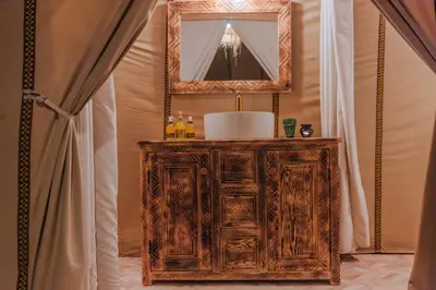 a mirror on top of a wooden cabinet in a bathroom at Luxury Camp Sahara in Merzouga
